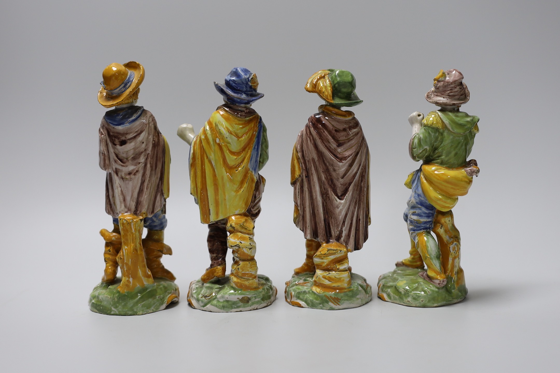 A set of four 19th century faience figures of street peddlers or performers - 18cm tall